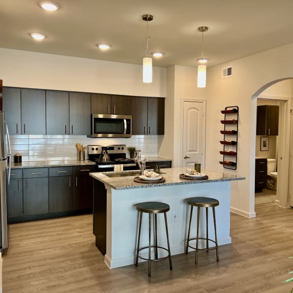 Thumbnail 2 of 13 Kitchen with granite island and pendant lighting 2 at High Point Preserve Apartments, Austin, TX 78724
