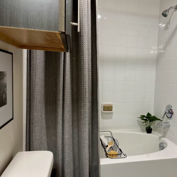 Thumbnail 8 of 13 Tiled bathtub with gray shower curtain and wall mount fixtures 2 at High Point Preserve Apartments, Texas, 78724