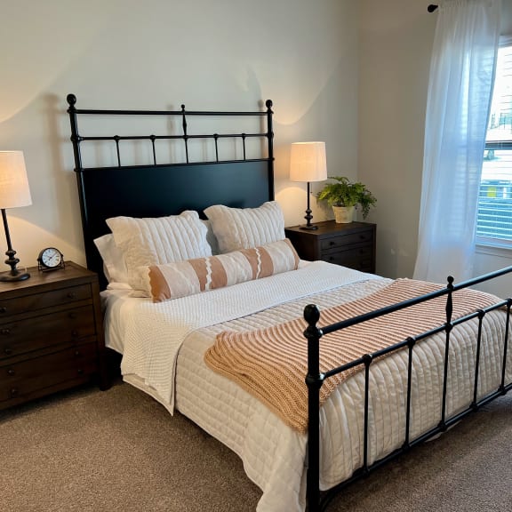 Thumbnail 10 of 13 Bedroom with black metal bed frame and white bedding at High Point Preserve Apartments, Austin, TX
