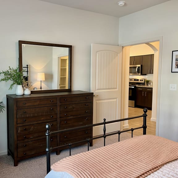 Thumbnail 11 of 13 Bedroom with dark wood dresser and black metal bed frame 2 at High Point Preserve Apartments, Austin, 78724