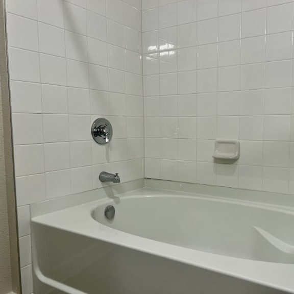 Thumbnail 17 of 19 Alcove bathtub with subway tile surround and chrome faucet at Bridge at Windsor Park Apartments, Austin, Texas