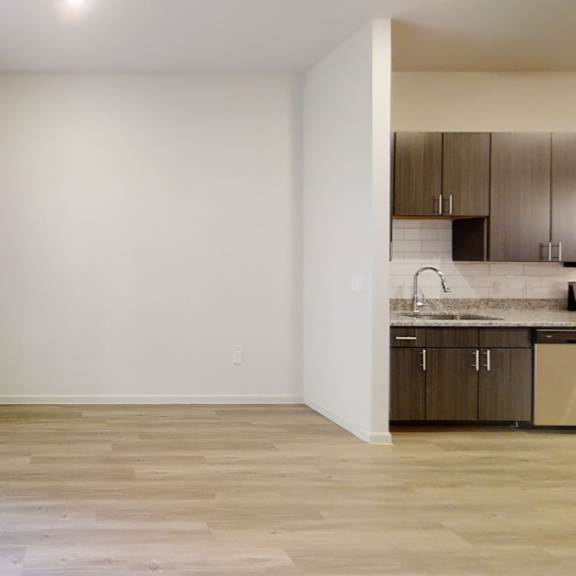 Thumbnail 4 of 5 a bedroom with a sliding glass door and a kitchen in the background