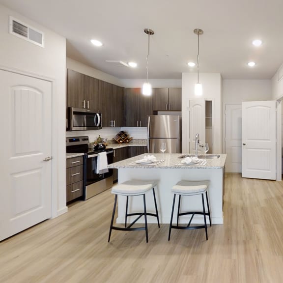 Thumbnail 2 of 8 a kitchen with a large center island with two stools
