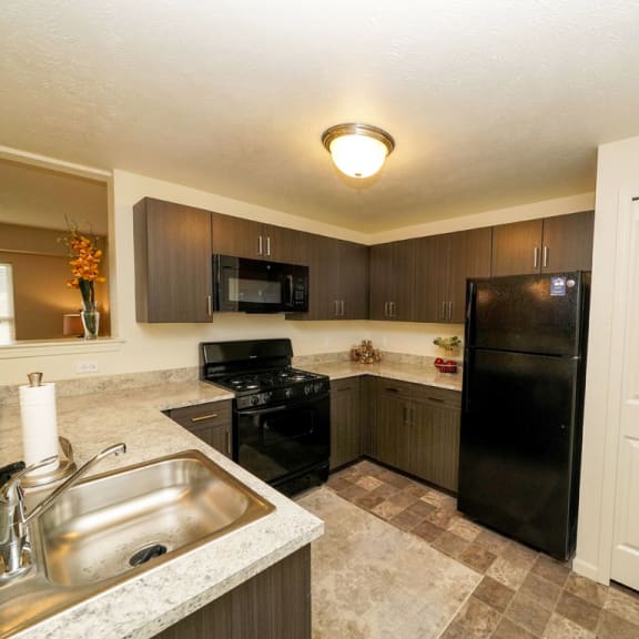 Thumbnail 5 of 9 a kitchen with a sink and a black refrigerator  at Andover Pointe Apartment Homes, La Vista