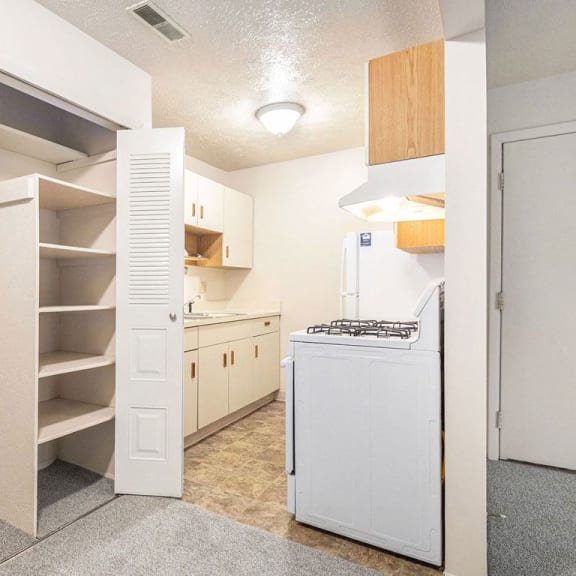 Thumbnail 10 of 14 a renovated kitchen with white appliances and a closet at Apple Ridge Apartments, Walker