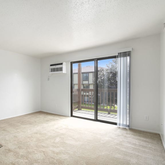 Thumbnail 3 of 14 an empty living room with a slider to a balcony at Apple Ridge Apartments, Michigan, 49534