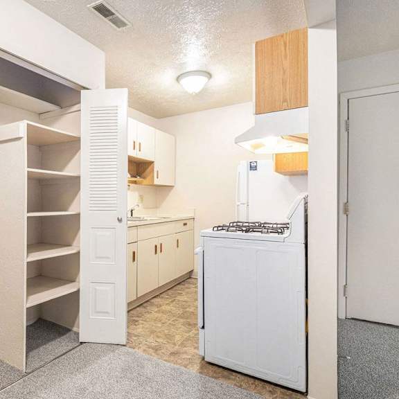 Thumbnail 4 of 7 A kitchen and a closet with shelving at Apple Ridge Apartments, Walker, MI, 49534