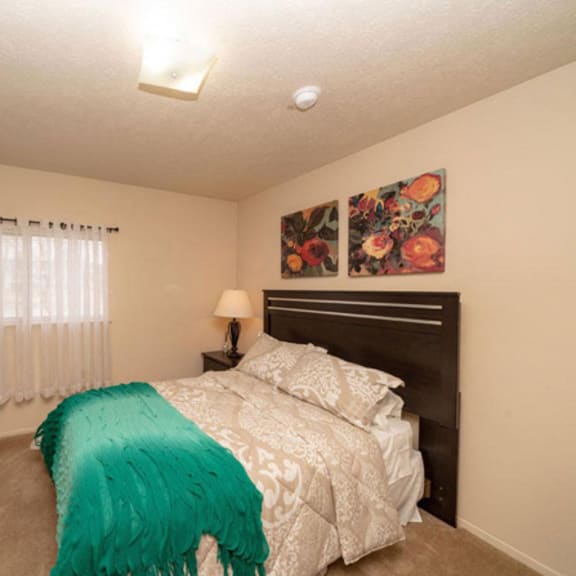 Thumbnail 13 of 13 a bedroom with a bed and a painting on the wall  at Arbor Lakes Apartments, Elkhart, IN, 46516