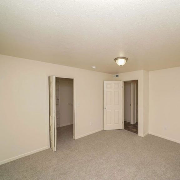 Thumbnail 12 of 13 an empty living room with a door to a hallway  at Arbor Lakes Apartments, Elkhart, IN, 46516