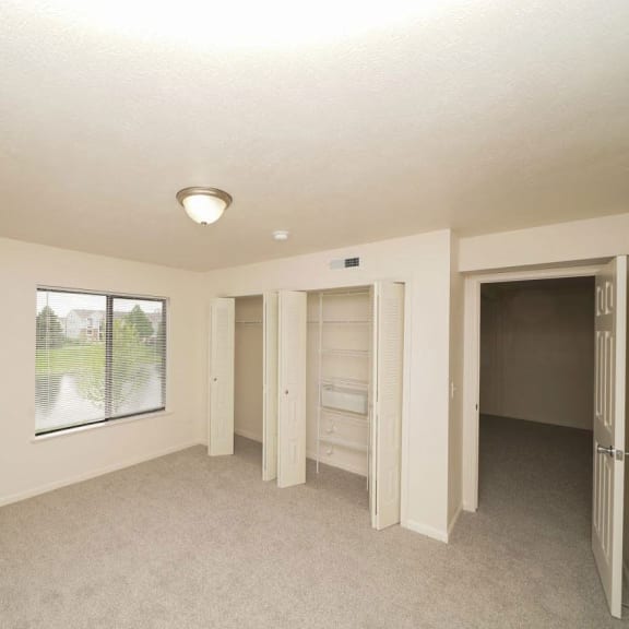 Thumbnail 9 of 13 an empty living room with a window and a closet  at Arbor Lakes Apartments, Indiana