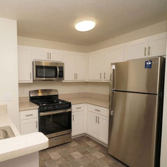 Thumbnail 6 of 13 a kitchen with stainless steel appliances and white cabinets  at Arbor Lakes Apartments, Indiana
