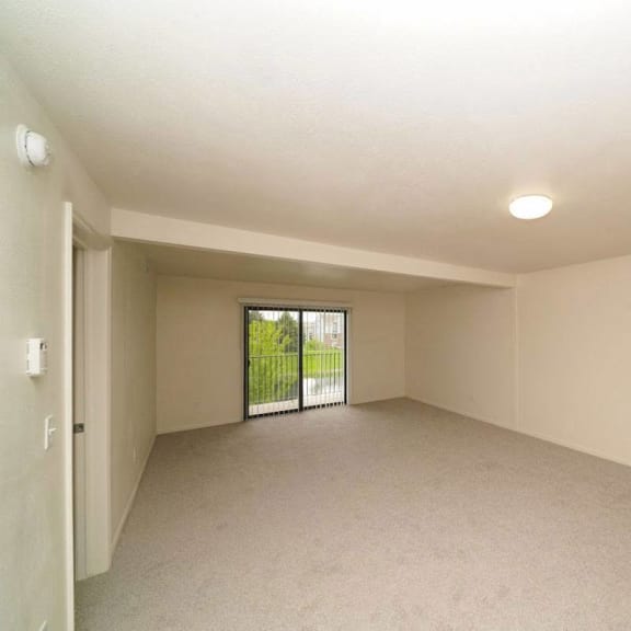 Thumbnail 3 of 13 an empty living room with a sliding glass door  at Arbor Lakes Apartments, Elkhart, IN, 46516