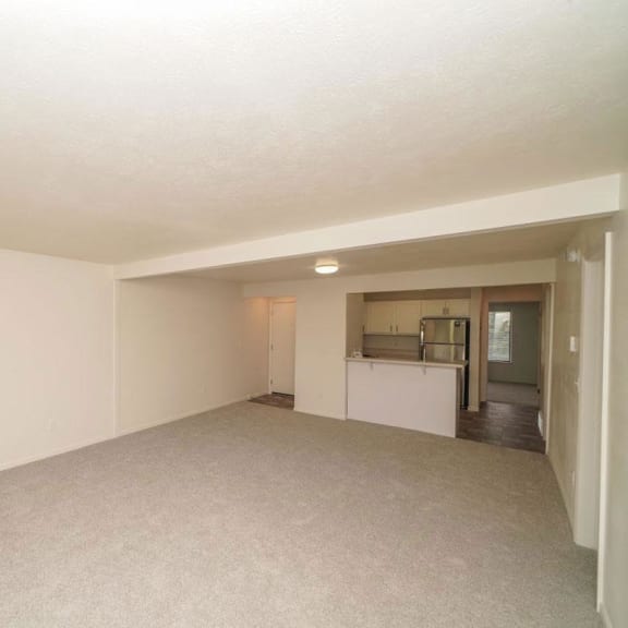 Thumbnail 4 of 13 an empty living room with a kitchen in the background  at Arbor Lakes Apartments, Elkhart, IN, 46516