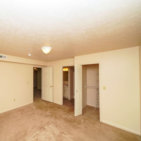Thumbnail 11 of 13 an empty living room with carpet and a hallway to a bathroom at Autumn Lakes Apartments and Townhomes, Mishawaka, 46544