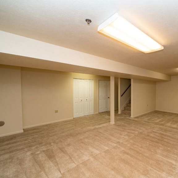 Thumbnail 14 of 14 an empty living room with a door to a staircase at Autumn Lakes Apartments and Townhomes, Mishawaka, IN