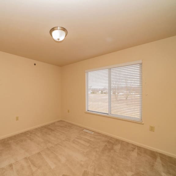 Thumbnail 8 of 11 an empty room with a window and a door at Autumn Lakes Apartments and Townhomes, Mishawaka, IN, 46544