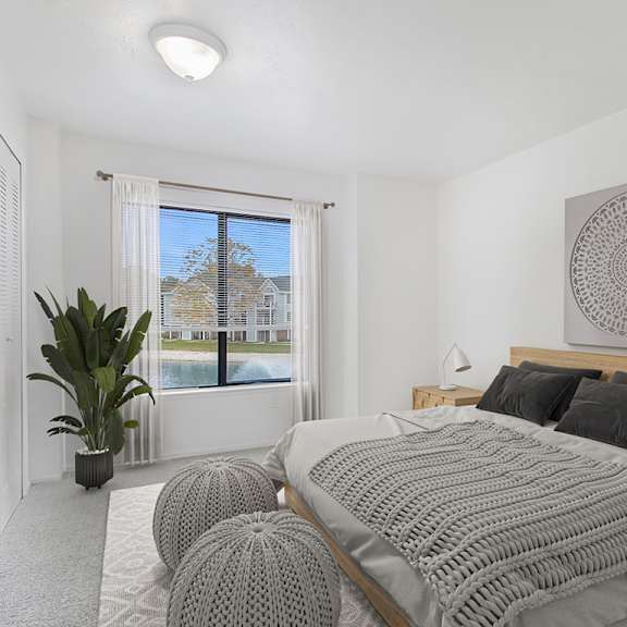Thumbnail 9 of 11 A bedroom with a large bed and a large window at Autumn Lakes Apartments and Townhomes in Mishawaka, IN