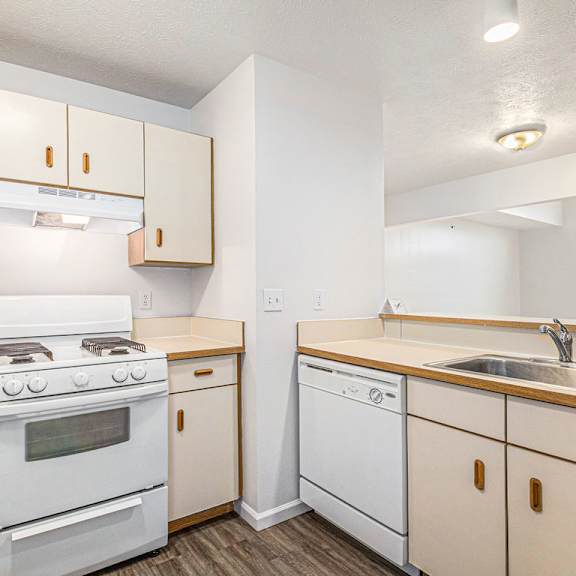 Thumbnail 5 of 11 A kitchen with white appliances and wooden cabinets at Autumn Lakes Apartments and Townhomes in Mishawaka, IN