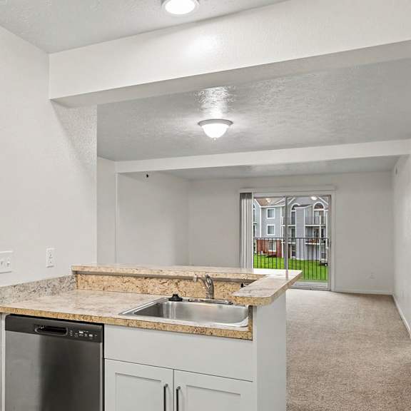 Thumbnail 8 of 22 A kitchen with a granite countertop and a dishwasher.