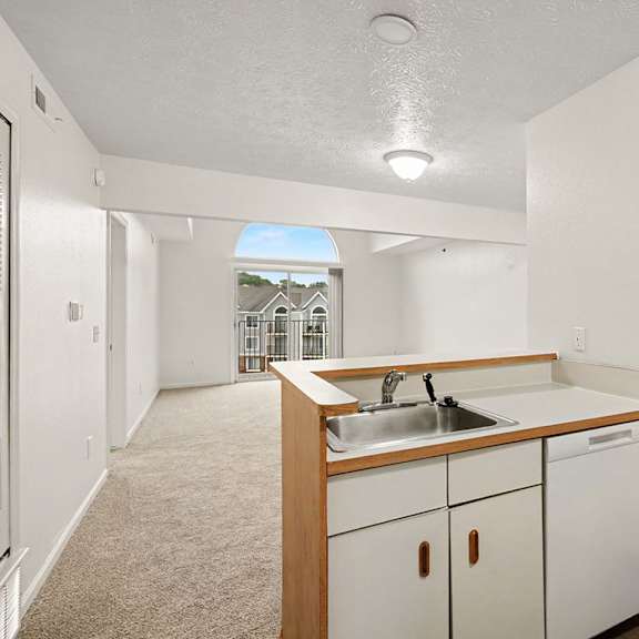 Thumbnail 6 of 22 A kitchen with white appliances and wooden cabinets.