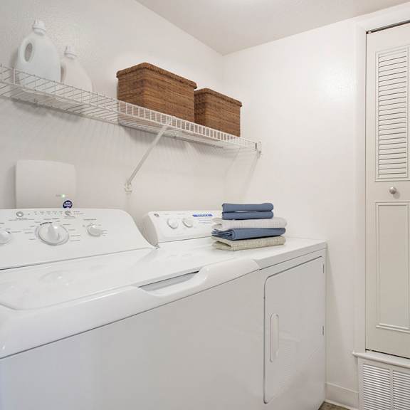 Thumbnail 7 of 11 A white washing machine and dryer in a small laundry room at Autumn Lakes Apartments and Townhomes in Mishawaka, IN