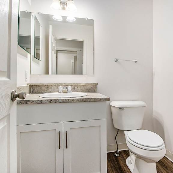 Thumbnail 8 of 16 A white toilet sits next to a sink in a bathroom at Autumn Lakes Apartments and Townhomes, Mishawaka, 46544