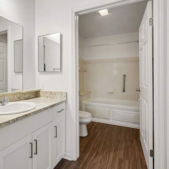 Thumbnail 15 of 18 A white bathroom with a sink, toilet, and bathtub.