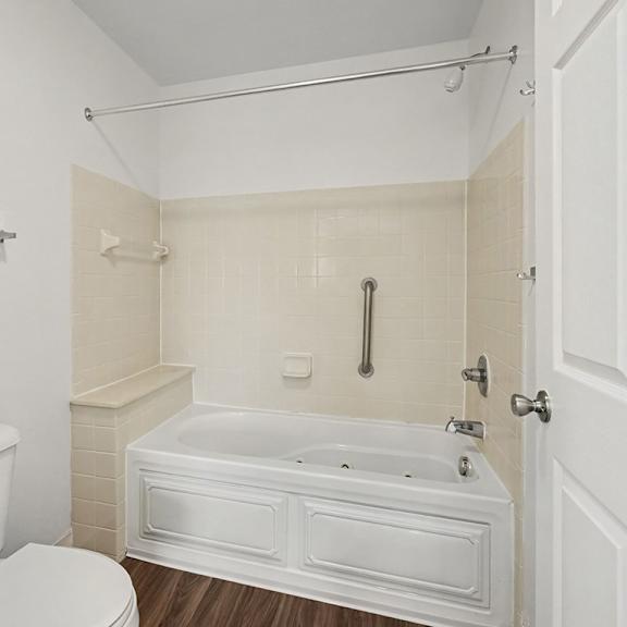 Thumbnail 16 of 18 A white bathroom with a toilet, tub, and shower.