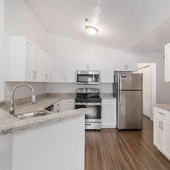 Thumbnail 5 of 12 A kitchen with white shaker-style cabinets and hard-surface countertops at Autumn Lakes Apartments and Townhomes, Mishawaka, 46544