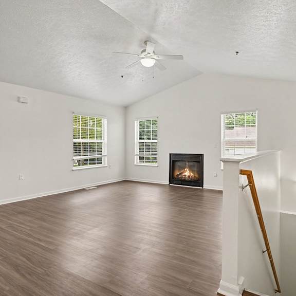 Thumbnail 3 of 18 A room with a fireplace and a wooden floor.