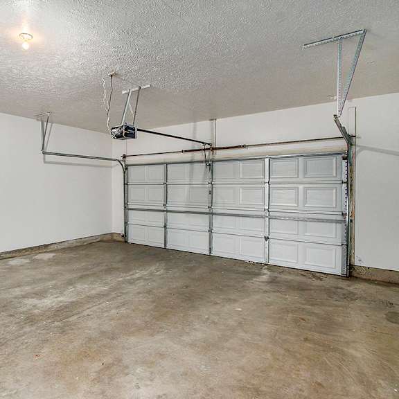 Thumbnail 14 of 14 A 2+ car garage with a white wall and a white door at Autumn Lakes Apartments and Townhomes, Mishawaka, 46544