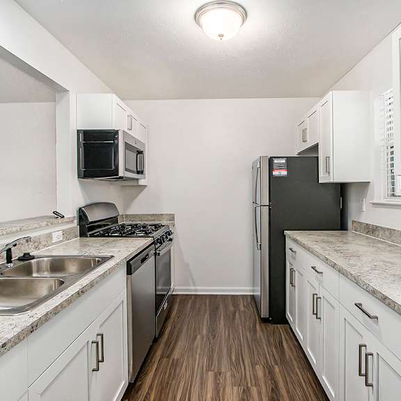 Thumbnail 6 of 14 A kitchen with white cabinets and a black refrigerator