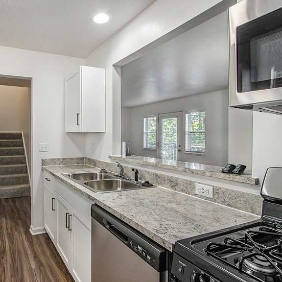 Thumbnail 5 of 14 A kitchen with white cabinets and a stainless steel refrigerator