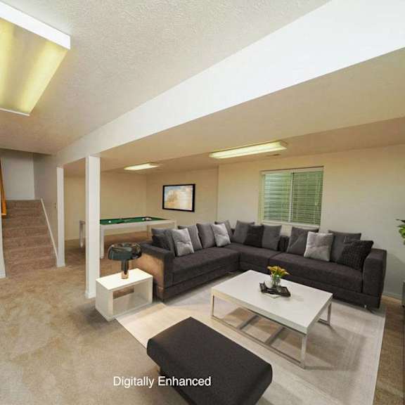 Thumbnail 15 of 15 A basement recreation room with a couch, coffee table, and a plant at Autumn Lakes Apartments and Townhomes, Indiana, 46544