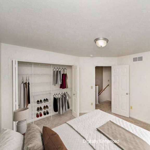 Thumbnail 10 of 15 A bedroom with a bed, a closet, and a plant at Autumn Lakes Apartments and Townhomes, Indiana, 46544