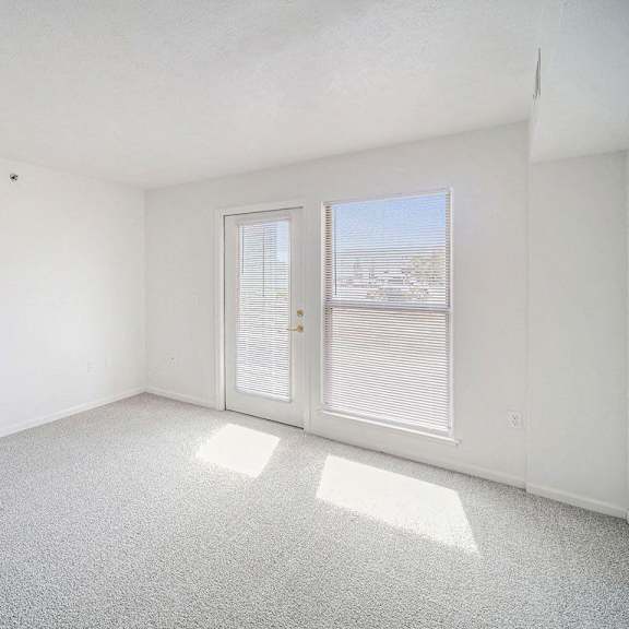 Thumbnail 4 of 10 carpeted living room with a door to a patio at Black Sand Apartment Homes in Lincoln, NE