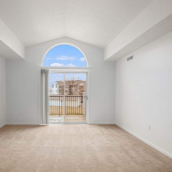 Thumbnail 4 of 14 A spacious living room with a view of a balcony at Black Sand Apartment Homes, Lincoln, Nebraska