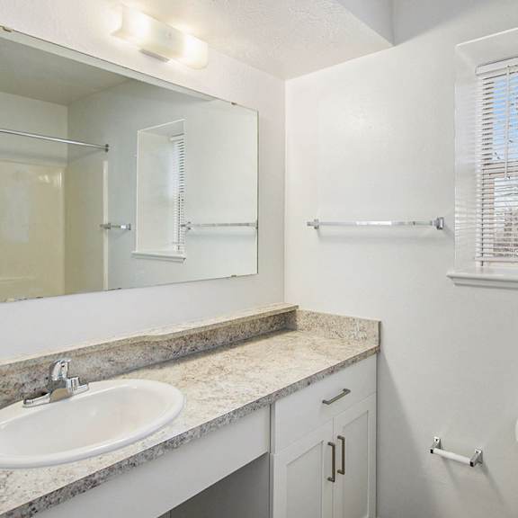 Thumbnail 10 of 12 A bathroom with white cabinets and a window at Brentwood Park Apartments, La Vista, 68128s.