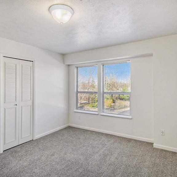 Thumbnail 12 of 12 A bedroom with large windows and a door to a walk in closet at Brentwood Park Apartments, La Vista, 68128