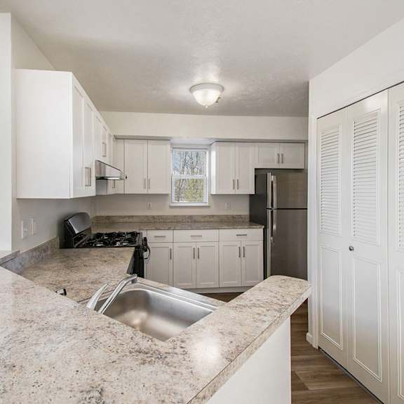 Thumbnail 6 of 12 A kitchen with white cabinets and a window at Brentwood Park Apartments, La Vista, 68128