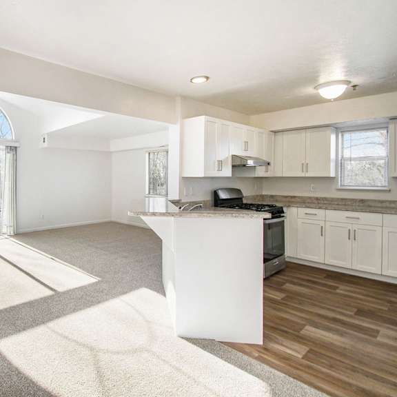 Thumbnail 3 of 12 A sunny day in an enlarged living room with a cathedral ceiling and kitchen at Brentwood Park Apartments, La Vista, 68128