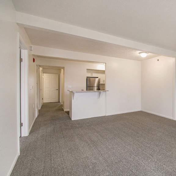 Thumbnail 5 of 16 A large living and dining room with a carpeted floor at Brentwood Park Apartments in LaVista, NE