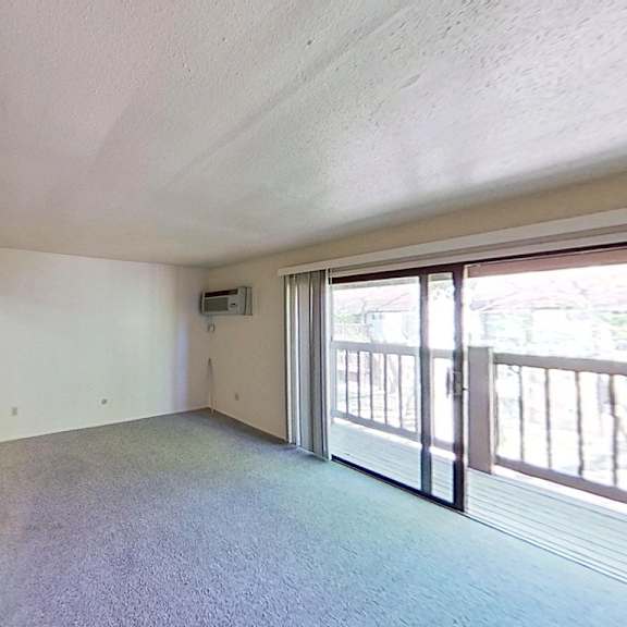Thumbnail 4 of 10 A spacious living room with a balcony at Briarwood Apartments in Benton Harbor, MI