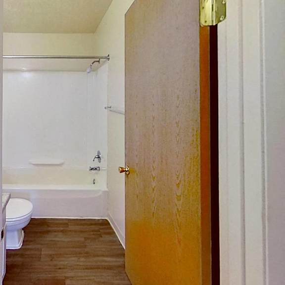 Thumbnail 9 of 12 A bathroom with a toilet, tub, and sink at Briarwood Apartments in Benton Harbor, MI