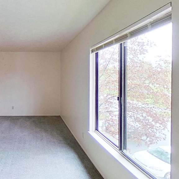 Thumbnail 11 of 12 A bedroom with a large window and a carpet at Briarwood Apartments in Benton Harbor, MI