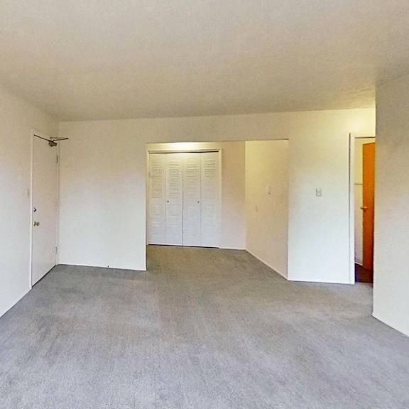 Thumbnail 5 of 12 A large empty living and dining room with a closet at Briarwood Apartments in Benton Harbor, MI