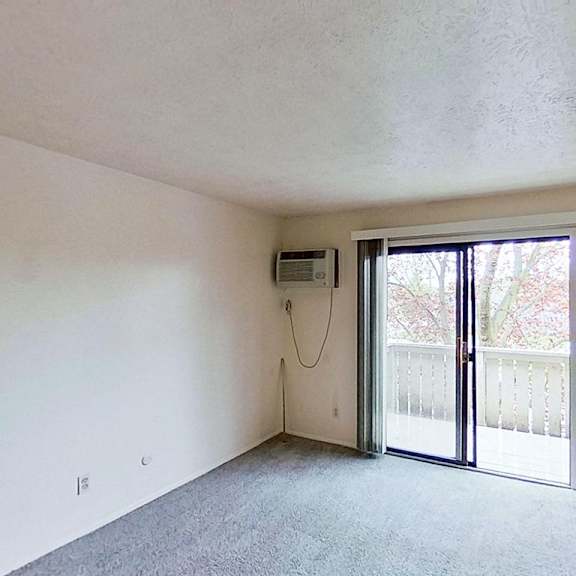 Thumbnail 4 of 12 A living room with a sliding glass door leading to a balcony at Briarwood Apartments in Benton Harbor, MI