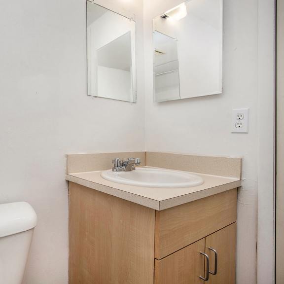 Thumbnail 15 of 19 A white toilet sits next to a sink in a bathroom at Brookside Apartments, Springfield