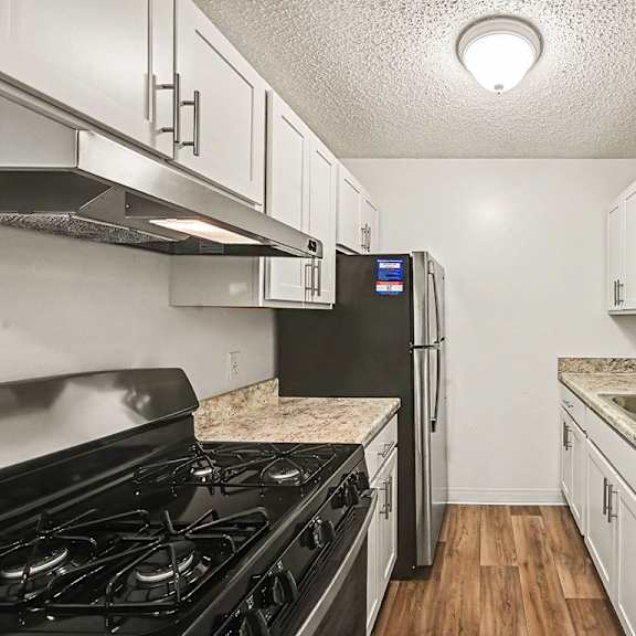 Thumbnail 12 of 19 A kitchen with a black stove top oven and a black refrigerator.