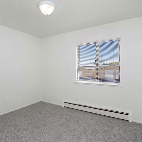 Thumbnail 13 of 13 A bedroom with a window and a grey carpet at Brookside Apartments, Springfield